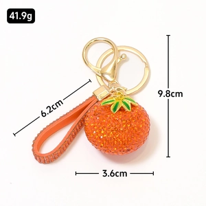 Portachiavi con arancia di strass, chiusura dorata e cinturino in pelle con cristalli