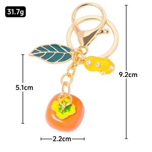 Golden persimmon and peanut keychain with sparkling rhinestones on a clean white background
