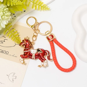 Dettaglio portachiavi a forma di cavallo in smalto rosso con strass e cinturino in pelle