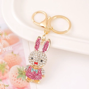 Detail of bunny keychain with pink rhinestones and gold alloy clasps on ceramic plate