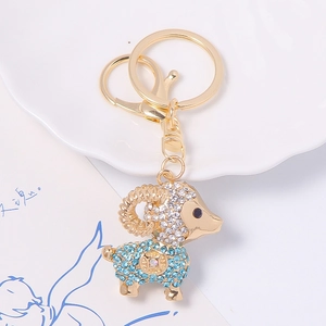 Détail du porte-clés chèvre en strass double face sur un plateau en porcelaine blanche