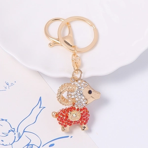Détail macro d'un porte-clés chèvre dorée avec strass rouges et motif de pièce