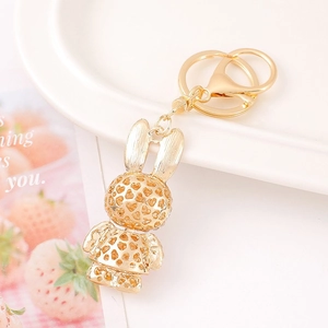 Golden rabbit keychain with heart-shaped hollow design on a white ceramic plate