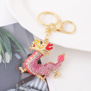 Detailed macro of golden Chinese dragon keychain with pink rhinestones on magazine background