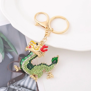 Detailed close-up of golden Chinese dragon keychain with green rhinestones and enamel accents