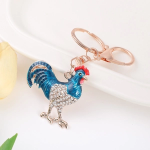 Portachiavi con gallo blu smaltato e cristalli su catena metallica oro rosa