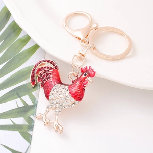 Macro di un portachiavi a forma di gallo con strass rossi e bianchi e finiture oro