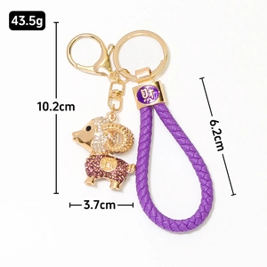 Porte-clés mouton doré avec strass violets et cordon en cuir tressé d'une longueur 10,2cm
