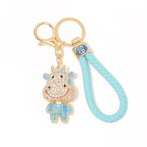 Dettaglio portachiavi mucca con strass blu, chiusura dorata e ciondolo con carattere Fu