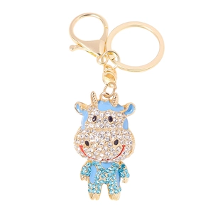Portachiavi con bue dei cartoni animati con strass blu e smalto dorato su sfondo bianco