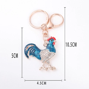 Dettaglio portachiavi a forma di gallo con strass e smalto blu, dimensioni 5x4,5cm