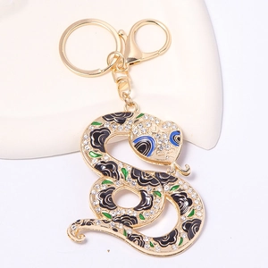 Vue détaillée d'un porte-clés serpent doré avec strass et motifs de roses en émail