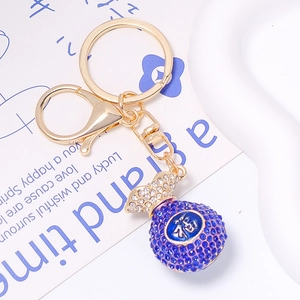Porte-clés sac de fortune doré orné de cristaux bleus avec le symbole Fu en gros plan