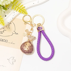Detail von lila Strass-Geldbeutel Schlüsselanhänger mit Lederband und goldenen Anhängern
