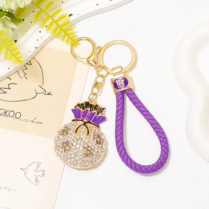 Dettaglio portachiavi a forma di sacchetto portafortuna con strass e cordino viola