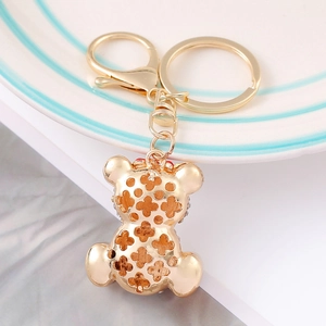 Detail of a gold bear keychain with hollow clover pattern and lobster clasp