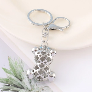 Detailed view of silver bear keychain with hollow clover pattern and lobster clasp closure