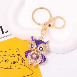 Detail of purple enamel owl keychain with sparkling rhinestones and gold-plated lobster clasp