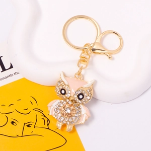 Macro view of crystal owl keychain with pink enamel wings and gold alloy lobster clasp