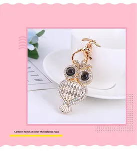 Détail d'un porte-clés hibou scintillant avec strass posé sur une tasse à café blanche