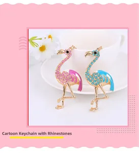 Detail of pink and blue flamingo keychains with rhinestones resting on a white ceramic cup