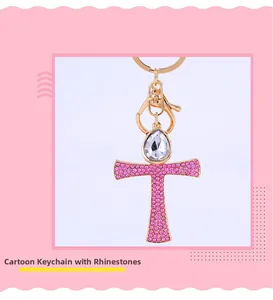 Detailed view of golden keychain with pink rhinestone cross and large crystal drop