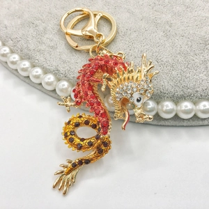 Macro detail of golden Chinese dragon keychain with vibrant red and yellow crystals