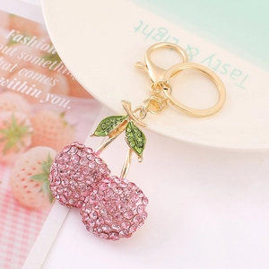 Dettaglio di un portachiavi a ciliegia con strass rosa, foglia d'oro e moschettone