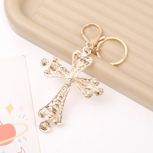 Luxury gold hollow cross keychain with intricate floral carving and pearl details