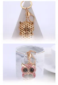 Macro detail of golden owl keychain with pink rhinestones and hollow floral backing