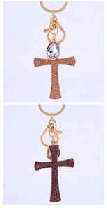 Detail of sparkling rhinestone encrusted cross keychains in pink and purple colors