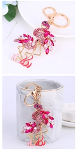 Porte-clés flamant rose avec strass présenté sur une tasse en marbre blanc