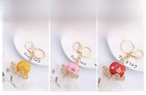 Détail de porte-clés carrosse citrouille avec émail coloré et strass incrustés