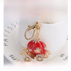 Détail du porte-clés carrosse citrouille en émail rouge avec strass et fermoir doré brillant