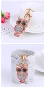Detailed view of owl keychain featuring pink and white rhinestones and gold alloy