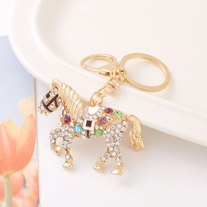 Golden horse keychain with colorful rhinestones and lobster clasp on white background