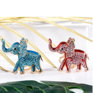 Sparkling elephant keychain with blue and pink rhinestones on a minimalist white stand