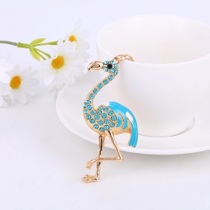 Cute flamingo keychain with blue rhinestones and gold metal plating on white background