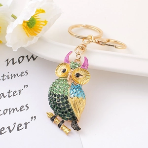 Détail macro du porte-clés hibou avec cristaux colorés et fermoir mousqueton doré