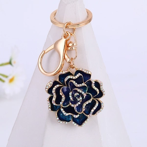 Blue enamel camellia flower keychain with gold edges and sparkling white rhinestones