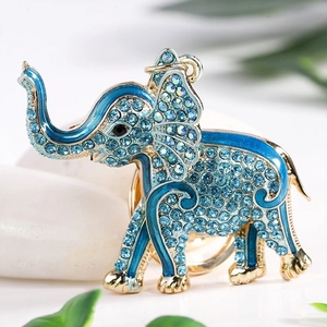 Macro detail of elephant keychain with blue rhinestones and gold plating on white stones