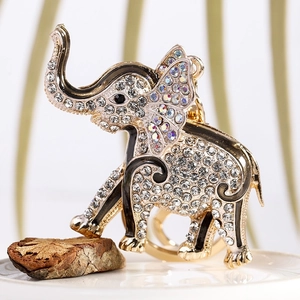 Detail shot of golden elephant keychain with sparkling rhinestones on wood and ceramic