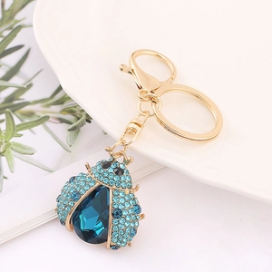 Detailed close-up of ladybug keychain with blue crystals and a gold lobster clasp
