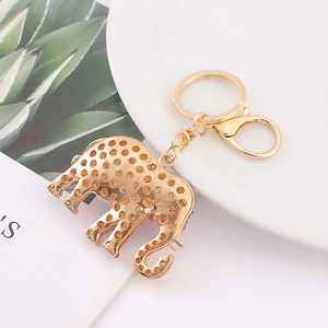 Golden elephant rhinestone keychain with lobster clasp on a white decorative plate