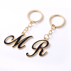 Goldenes Metall-Schlüsselanhänger-Set mit schwarzen Emaille-Buchstaben M und R