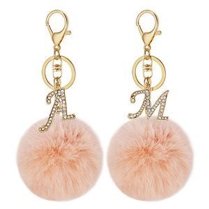 Detail view of pink faux fur ball keychains with crystal-encrusted A and M letters