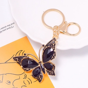 Close-up of golden butterfly keychain featuring intricate black rhinestones and crystals