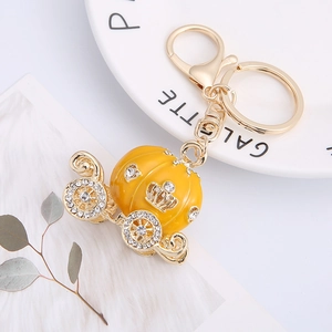 Golden alloy pumpkin carriage keychain with yellow enamel and sparkling rhinestones