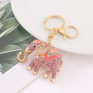 Close-up of golden elephant keychain with pink rhinestones and enamel flowers