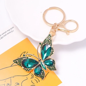 Detailed macro view of butterfly keychain with green crystals and gold alloy lobster clasp